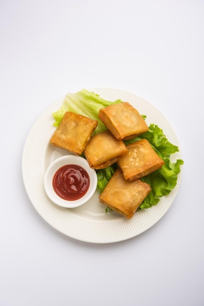 Le samosa chinois aux légumes est une forme carrée d'une collation frite préparée avec des feuilles de pâtisserie maison et de délicieuses nouilles farcies