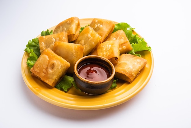 Le samosa chinois aux légumes est une forme carrée d'une collation frite préparée avec des feuilles de pâtisserie maison et de délicieuses nouilles farcies