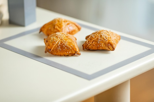 Samosa fraîchement cuit sur un tapis de cuisson sur une table de cuisine à domicile