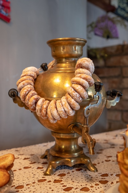 Photo samovar doré avec séchoirs et beignets