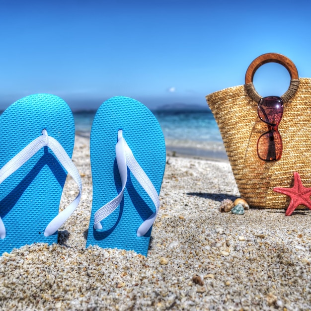 Photo sandales bleues et sac de paille au bord de la mer en hdr