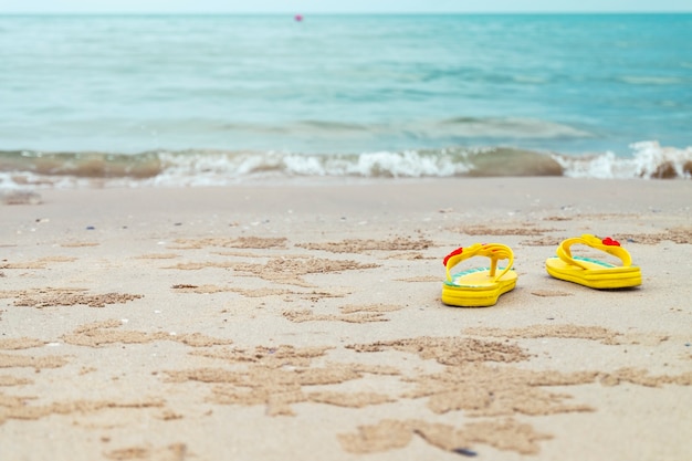 Sandales jaunes sur la plage.