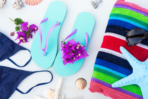 Sandales de plage d'été avec maillot de bain, serviette de plage et étoile de mer.