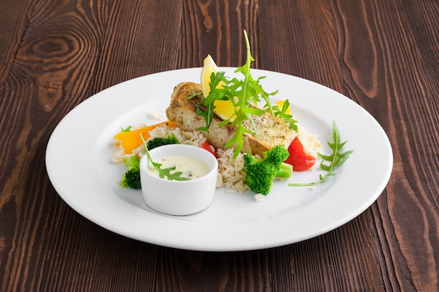 Sandre Frite Avec Riz, Poivron Et Roquette Servi Avec Sauce Mayonnaise Sur Table En Bois Foncé