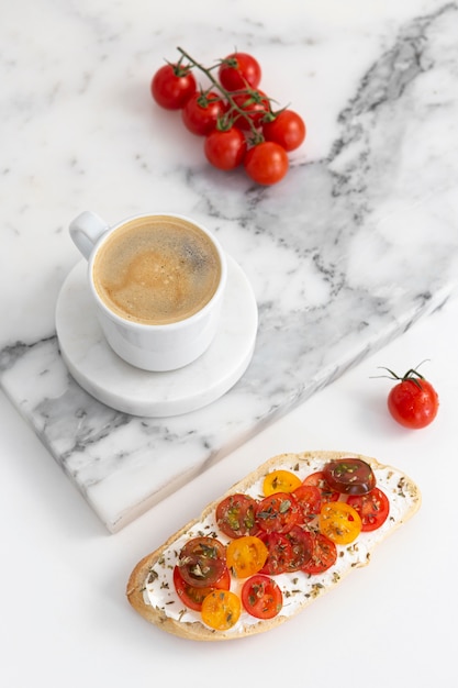 Sandwich à angle élevé avec fromage à la crème et tomates avec tasse de café