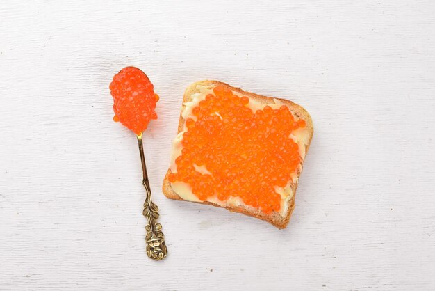 Sandwich au caviar rouge et beurre Sur un fond en bois Vue de dessus Espace libre pour le texte