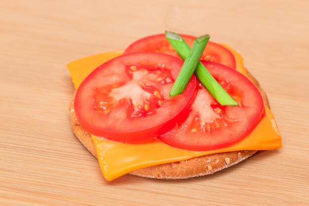 Sandwich au cracker croustillant avec du fromage à la tomate et des oignons verts