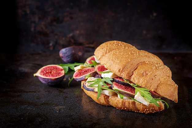 Sandwich au croissant frais avec roquette au fromage brie et figues. Délicieux petit déjeuner. Nourriture savoureuse.