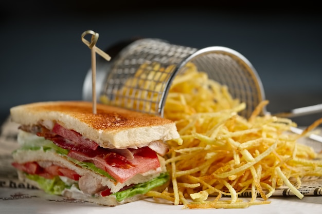 Sandwich au fromage, bacon, tomates, salade verte et rouge et frites