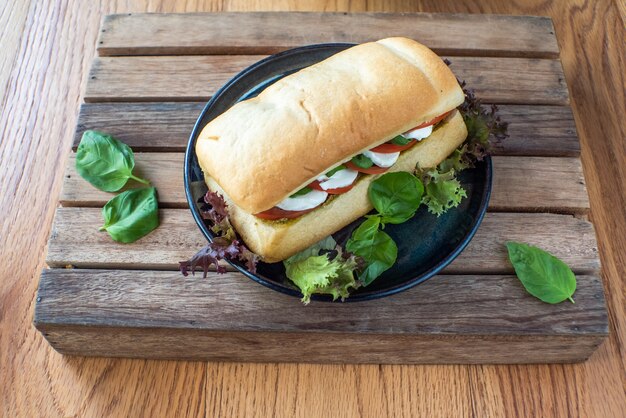 Sandwich au fromage, tomate, concombre et laitue et légumes à part