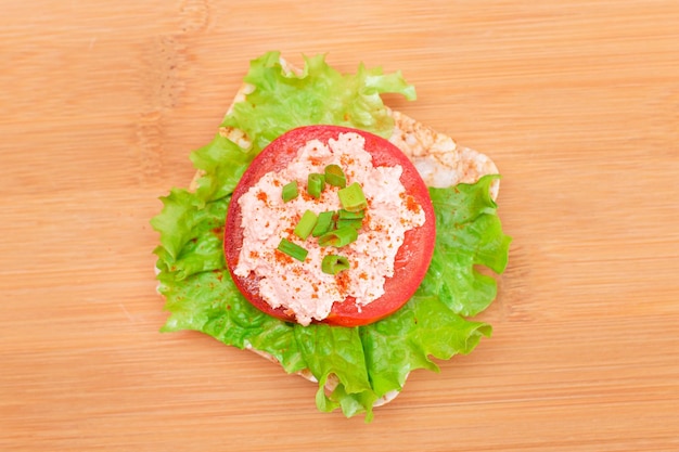 Sandwich au gâteau de riz avec crème de poisson à la laitue de tomate et oignons verts