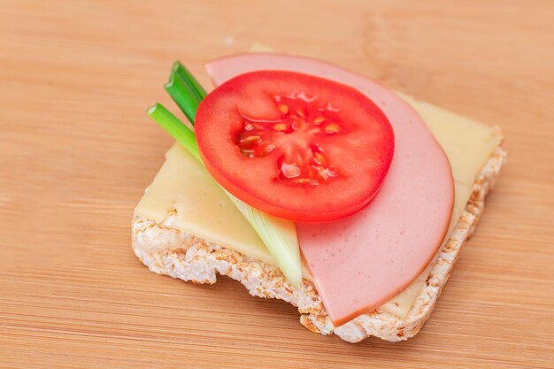 Sandwich au gâteau de riz avec des oignons verts à la saucisse de tomate et du fromage