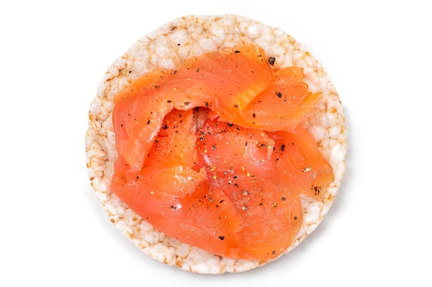 Sandwich au gâteau de riz avec des tranches de saumon frais isolées sur du blanc