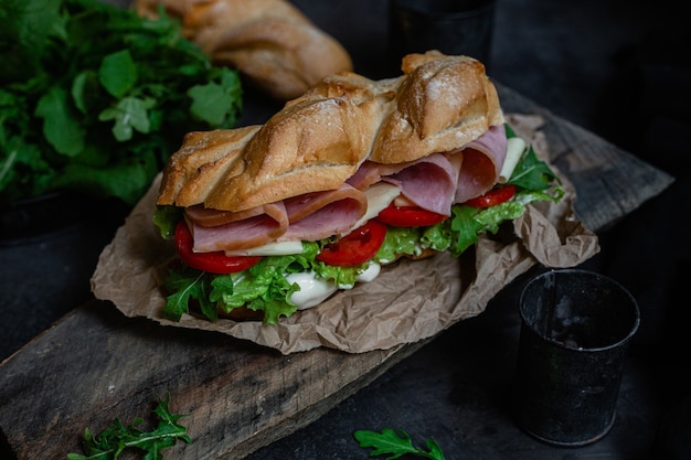 Sandwich au jambon fromage tomate et laitue sur fond sombre