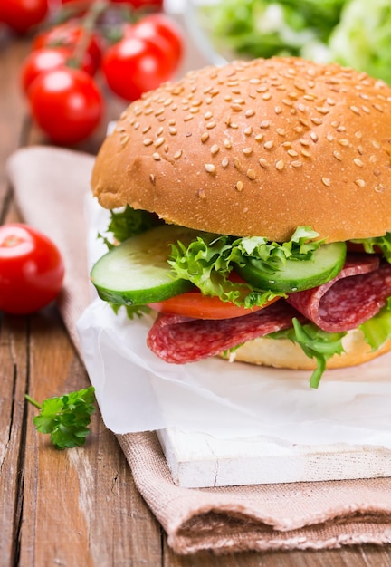 Sandwich au jambon et légumes sur fond de bois