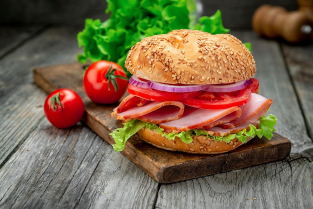 Sandwich au jambon et légumes sur une vieille table en bois