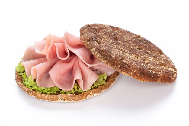 Sandwich au jambon de porc sur fond blanc.