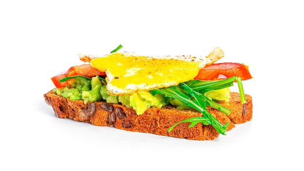 Sandwich au pain de seigle avec guacamole, roquette, tomates et œuf de caille isolé. Bruschetta à l'avocat. Petit-déjeuner sain.