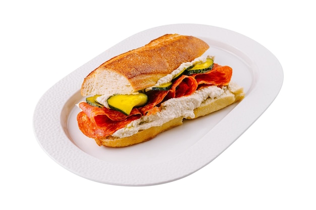 Photo un sandwich au pepperoni et aux légumes sur une assiette blanche.