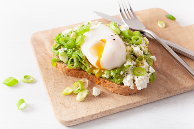 Sandwich au petit déjeuner à l'avocat avec œuf poché et fromage feta