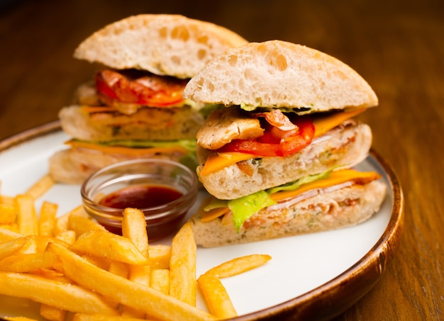 Photo un sandwich au poulet avec des frites sur une assiette.