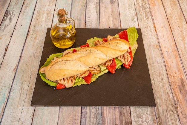 Sandwich au poulet de style méditerranéen avec piments piquillos rôtis filets de poulet grillés et feuilles de laitue à l'huile d'olive