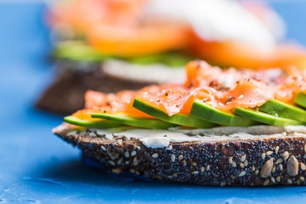 Sandwich au saumon fumé et avocat. Concept pour une alimentation saine.