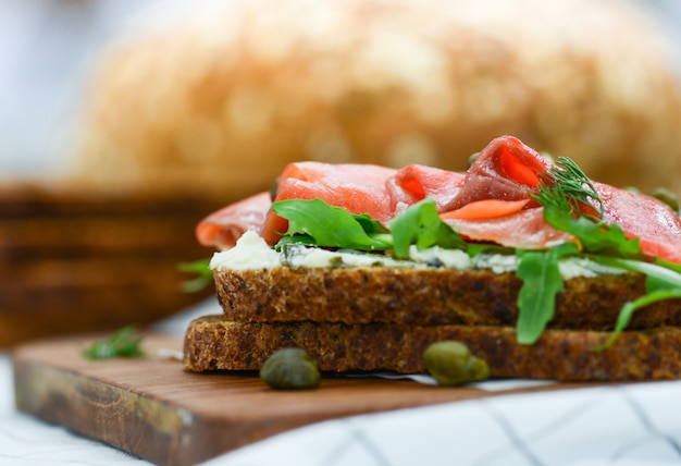 Sandwich au saumon fumé avec fromage, pistache et feuilles de salade, pains bruns