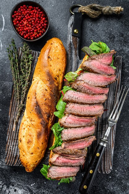 Sandwich au steak maison avec du rosbif en tranches, roquette et fromage