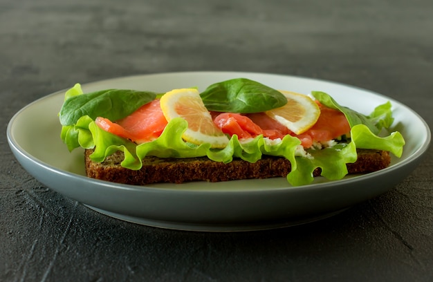 Sandwich au treillis de saumon fumé et citron. Concept pour un repas savoureux et sain. Nourriture sur une assiette