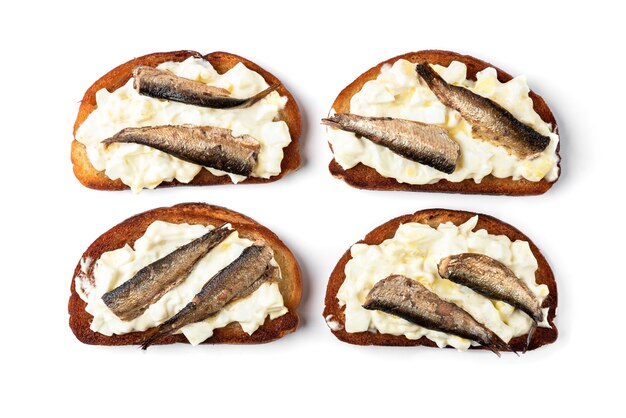 Sandwich aux sprats, œufs et mayonnaise isolé sur une surface blanche.