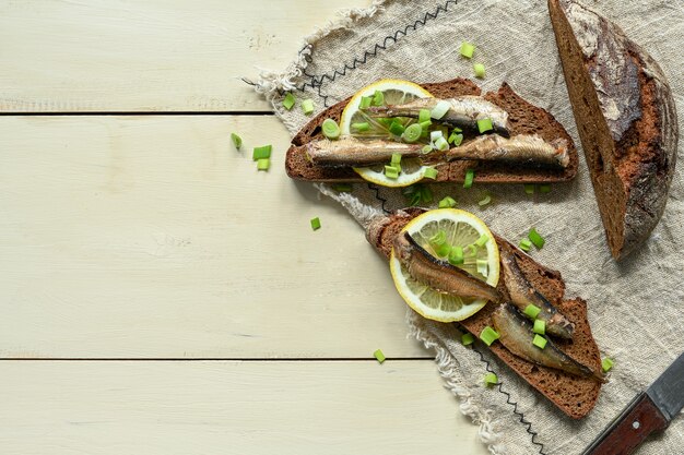 Sandwich aux sprats. Sprat dans l'huile. Sur un fond en bois.