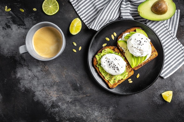 Photo sandwich à l'avocat et aux œufs pochés pain complet toast avocat en tranches et œuf avec une tasse de café pour un petit-déjeuner sain ou un en-cas copiez l'espace