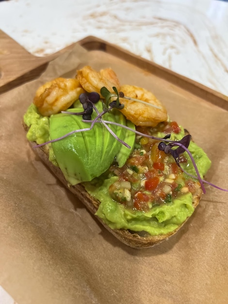 Un sandwich à l'avocat et à l'avocat sur une planche à découper.