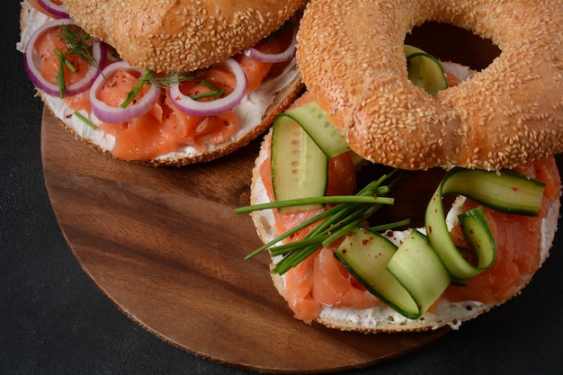 Sandwich bagel au saumon, fromage à la crème, concombre et oignons