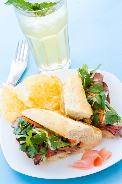 Sandwich banh-mi gastronomique avec des frites sur le côté.