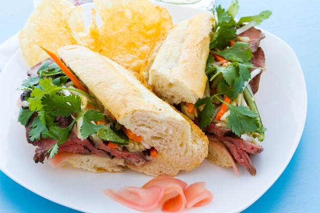 Sandwich banh-mi gastronomique avec des frites sur le côté.