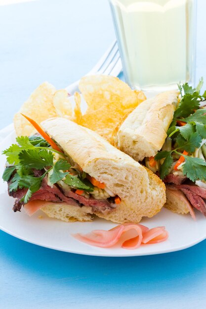 Sandwich banh-mi gastronomique avec des frites sur le côté.