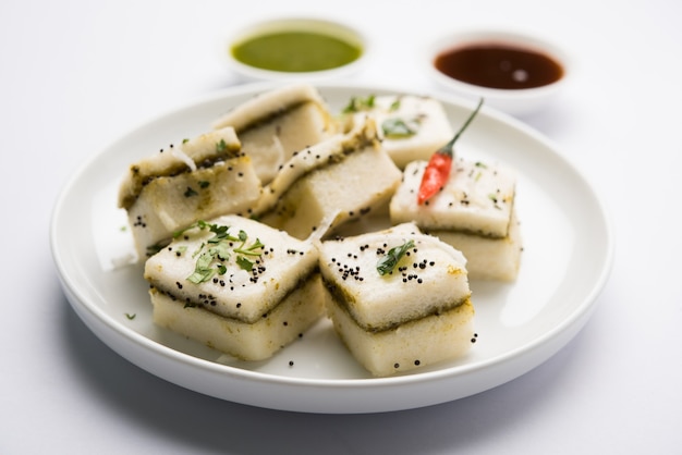 Le sandwich blanc Dhokla est un en-cas salé indien à base de farine de pois chiches ou de farine de riz, originaire du Gujarat. Servi avec chutney vert et tamarin. mise au point sélective