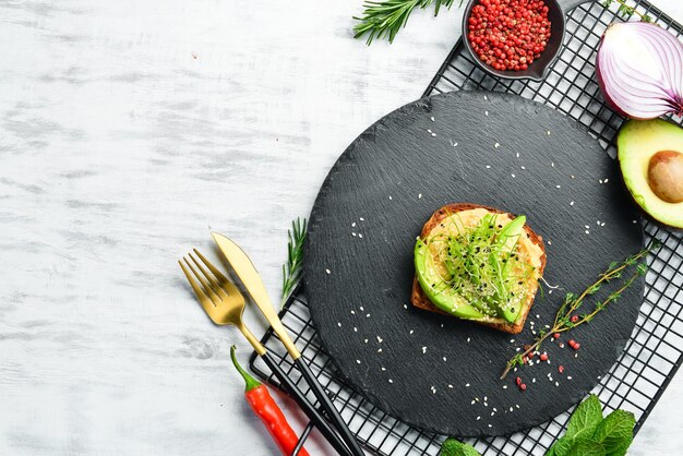 Sandwich ciabatta avocat houmous et microgreen Petit Déjeuner Sur une plaque en pierre noire