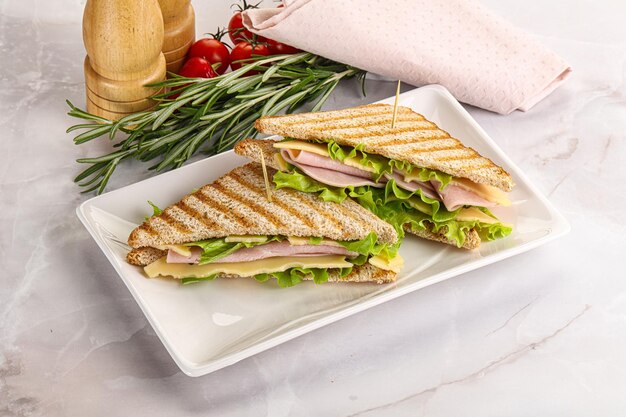 Un sandwich de club fait maison avec du jambon et du fromage.