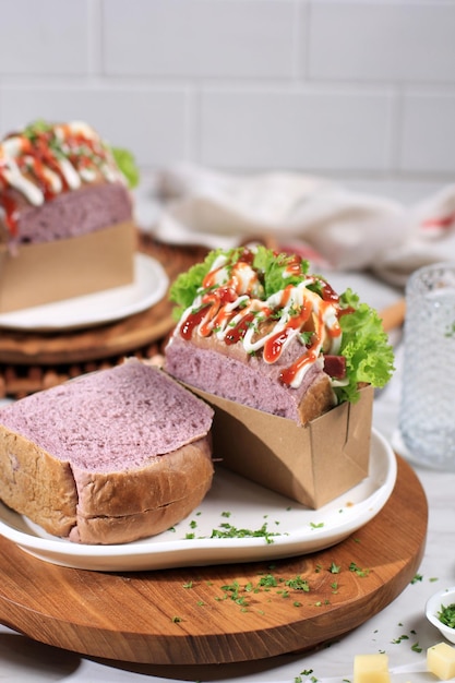 Sandwich coréen Pain violet Goutte d'œufs avec laitue aux œufs Mayonaise Fromage Sauce au persil Servi avec du lait Concept de fond blanc pour la boulangerie