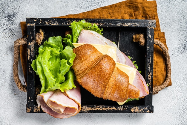 Sandwich croissant frais avec jambon fromage et feuille de salade Fond gris Vue de dessus