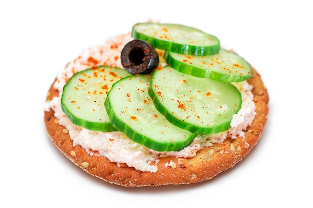 Sandwich croustillant aux craquelins avec crème de poisson au concombre frais et olives isolées