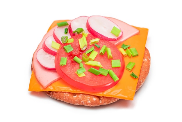 Sandwich croustillant aux craquelins avec fromage à la saucisse de tomate, oignons verts et radis isolés