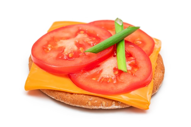 Sandwich croustillant aux craquelins avec fromage tomate et oignons verts isolés