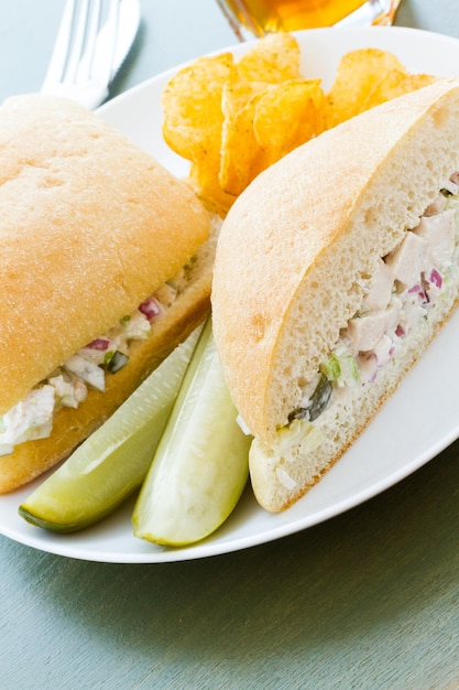 Sandwich gourmet à la salade de poulet avec frites sur le côté.