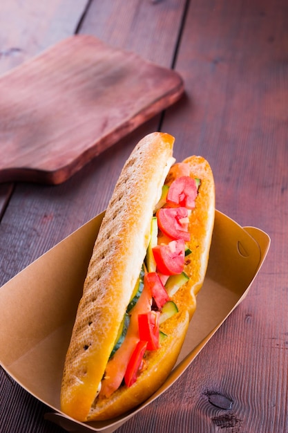 Sandwich grillé avec des légumes dans une boîte en papier Sandwich avec des tomates et des concombres