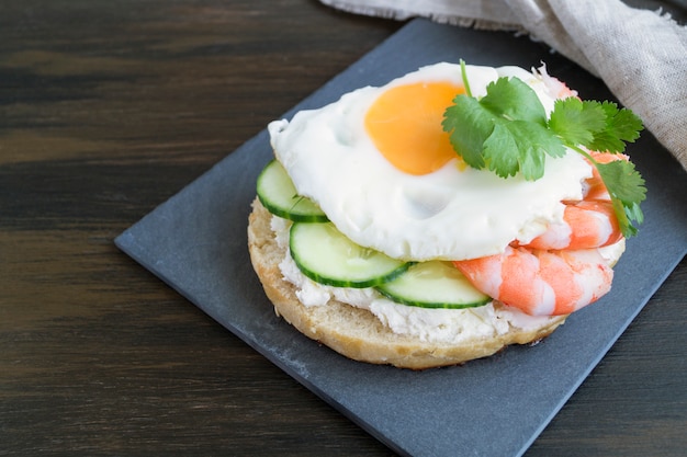 Sandwich oeuf et concombre sur fond en bois.