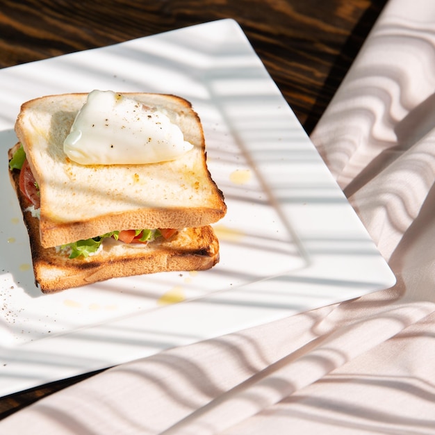 sandwich avec oeuf poché et jambon isolé sur fond vert copie espace gros plan